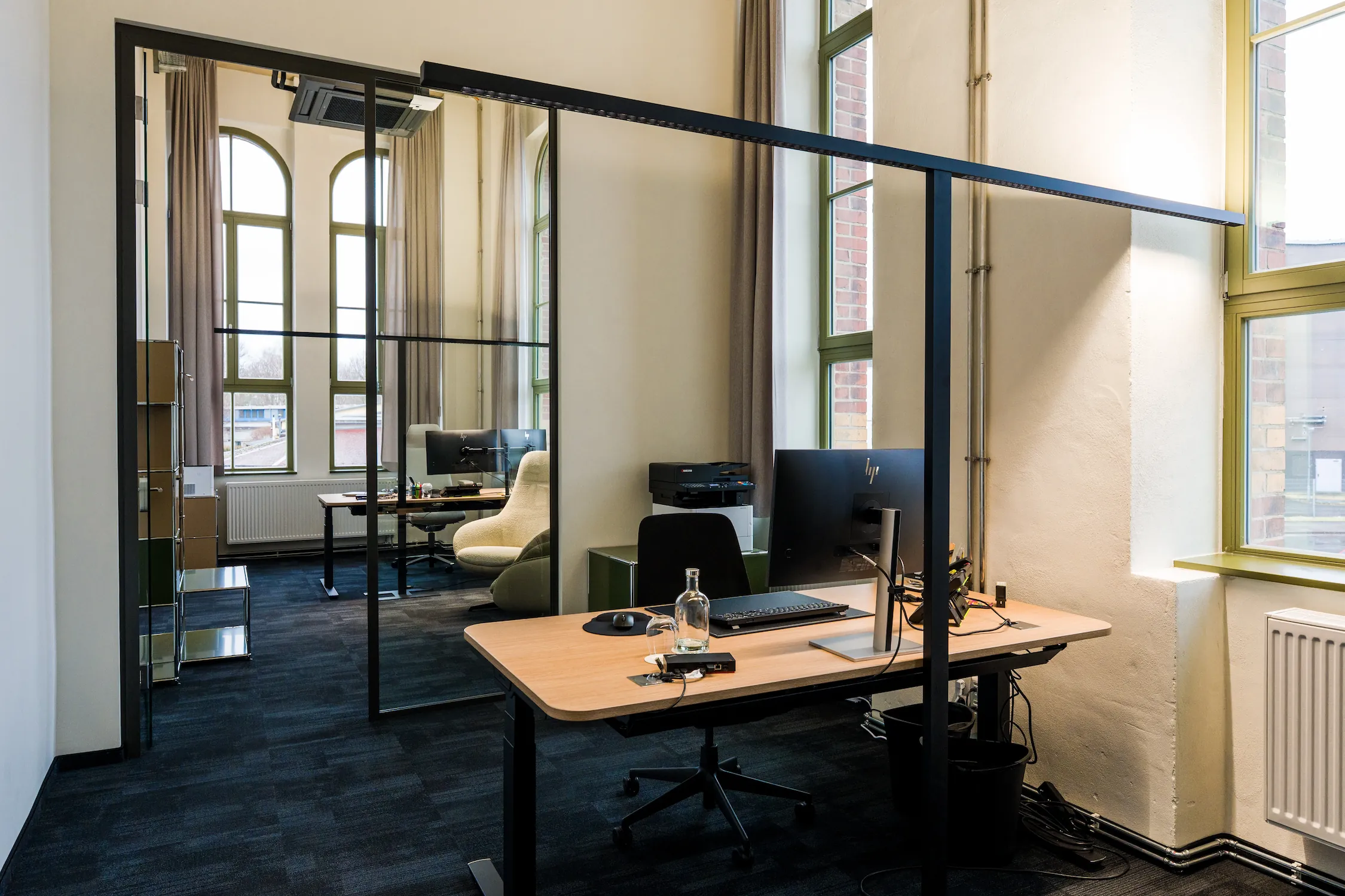 Einzelbüro mit Glaswand und historischen Bogenfenstern