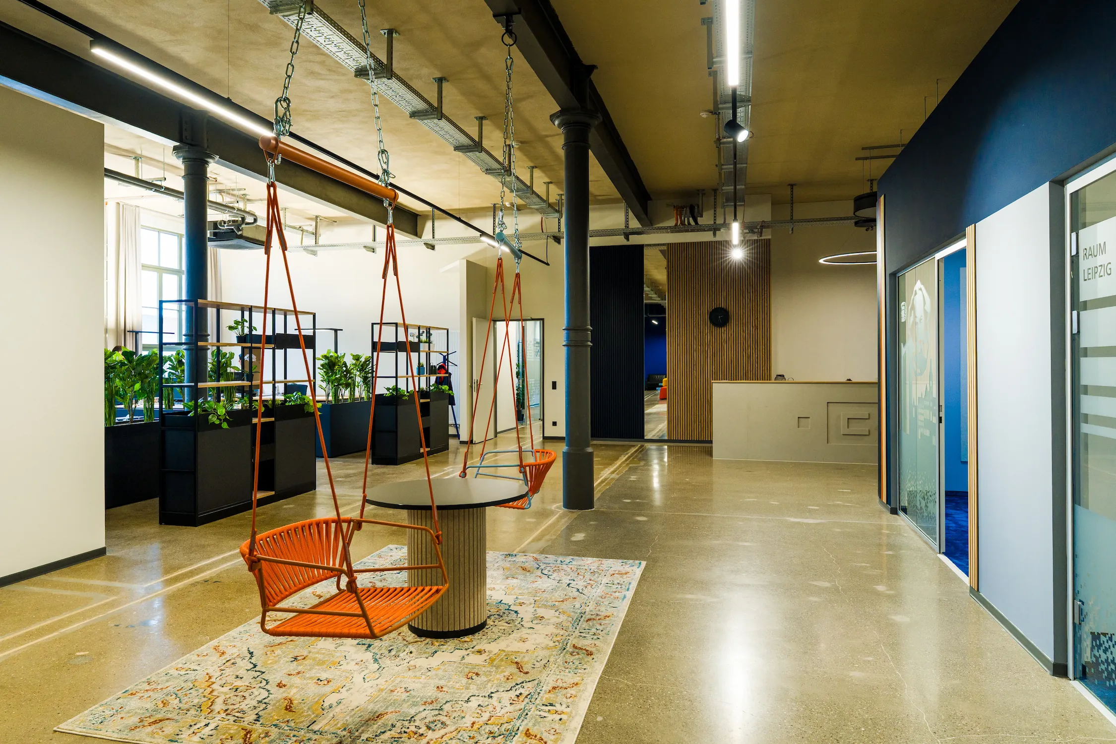 Kreative Lobby mit Hängeschaukeln und Industriecharme